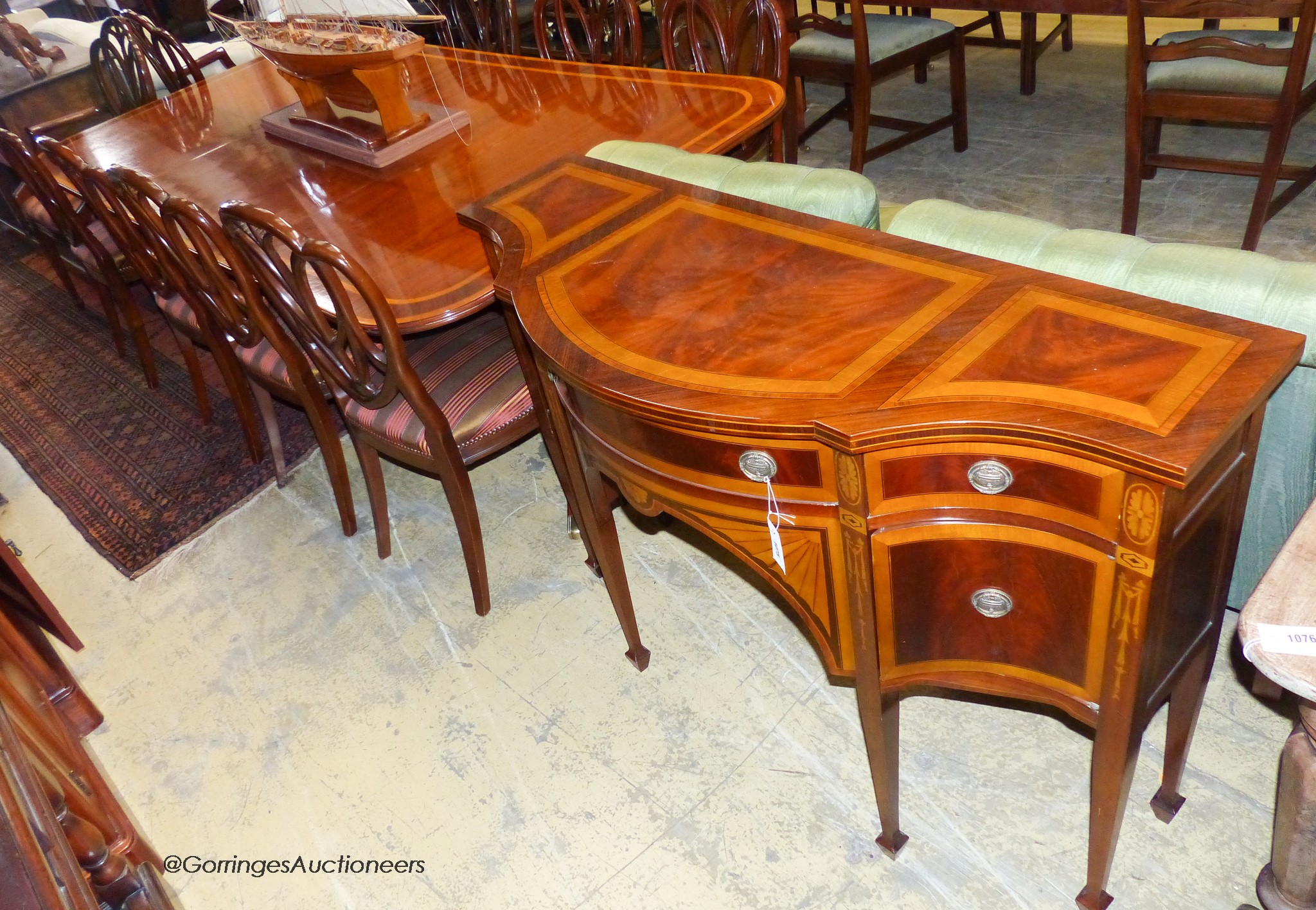 A reproduction Sheraton inlaid mahogany dining room suite, comprising twin pillar extending dining table, 240cm extended, one spare leaf, ten chairs, two with arms and sideboard. W-124, H-72cm.